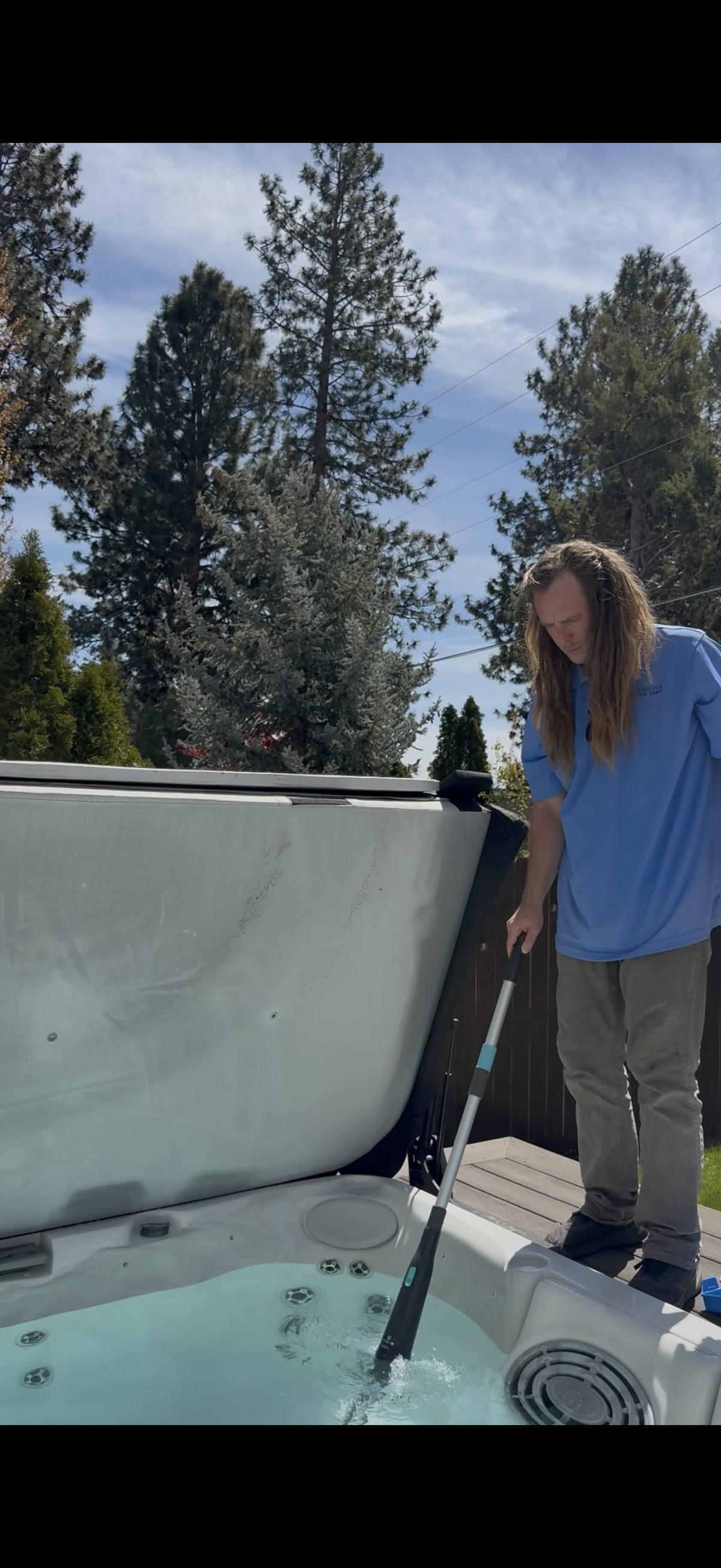 Hot tub vacuuming service in Bend, Oregon backyard with pine trees